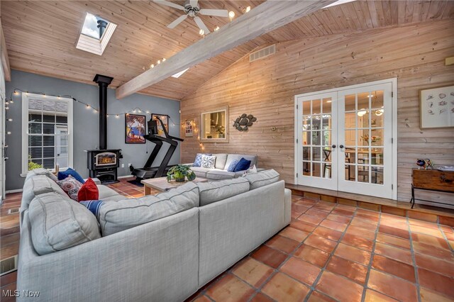 561 Willard Rd, Aurora, OH 44202 - living area featuring wooden walls, french doors, a skylight, a wood stove, and tile patterned floors