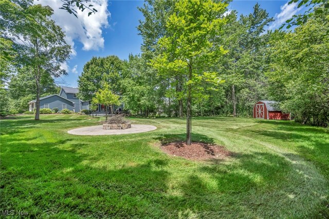 561 Willard Rd, Aurora, OH 44202 - view of grassy yard featuring a storage unit and an outdoor fire pit