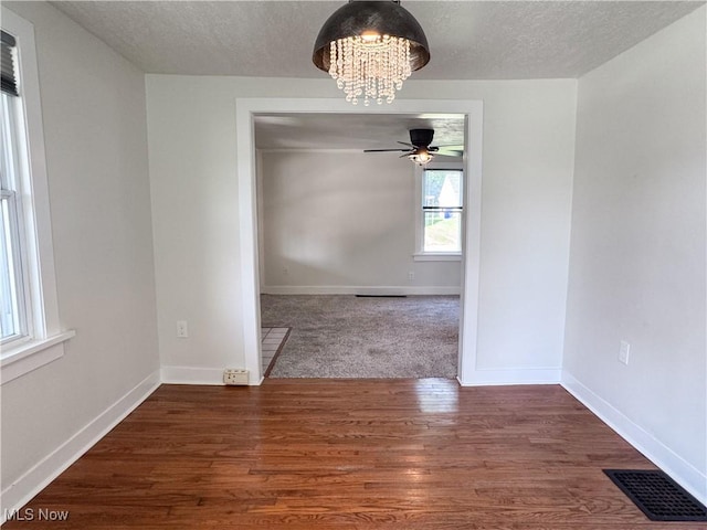 114 Hillcrest St, Ravenna, OH 44266 - unfurnished dining area featuring a chandelier, a textured ceiling, ceiling fan, and wood finished floors