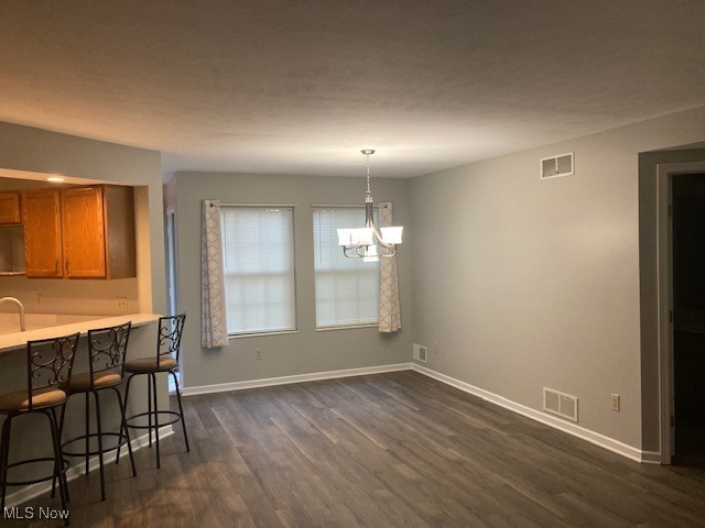 205 S Aspen Unit 4, Warren, OH 44484 - unfurnished dining area with a chandelier and dark wood-style flooring