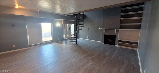 2202 Acacia Park Dr Unit 2605, Lyndhurst, OH 44124 - unfurnished living room with stairs, wood finished floors, a textured ceiling, and a fireplace