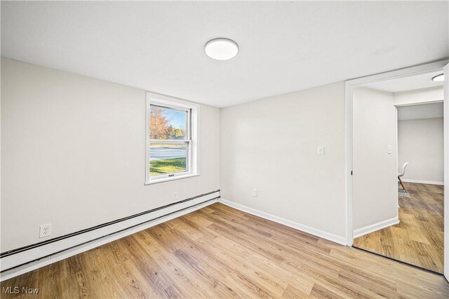 30529 Ridge Rd, Wickliffe, OH 44092 - unfurnished bedroom with baseboard heating and light wood-type flooring