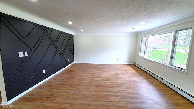 30529 Ridge Rd, Wickliffe, OH 44092 - unfurnished bedroom featuring a baseboard radiator, a textured ceiling, wood finished floors, and recessed lighting