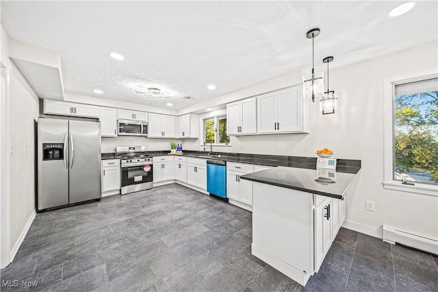 30529 Ridge Rd, Wickliffe, OH 44092 - kitchen featuring appliances with stainless steel finishes, dark countertops, a peninsula, recessed lighting, and white cabinetry