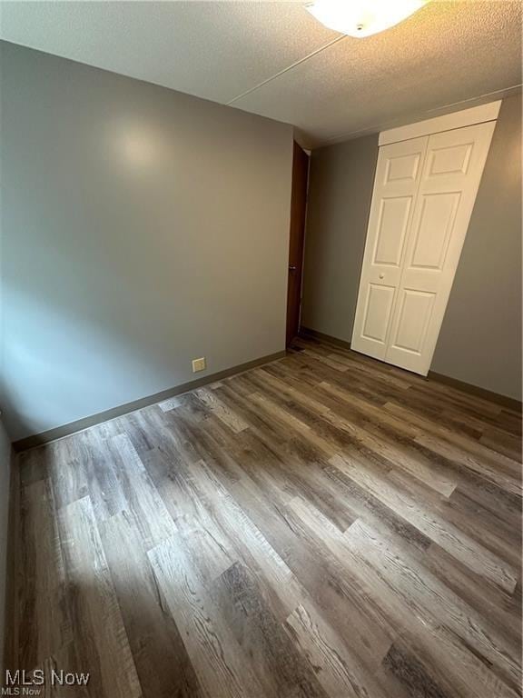 7443 Spillway Rd Unit 63, Lisbon, OH 44432 - unfurnished bedroom featuring dark wood finished floors, a closet, and a textured ceiling