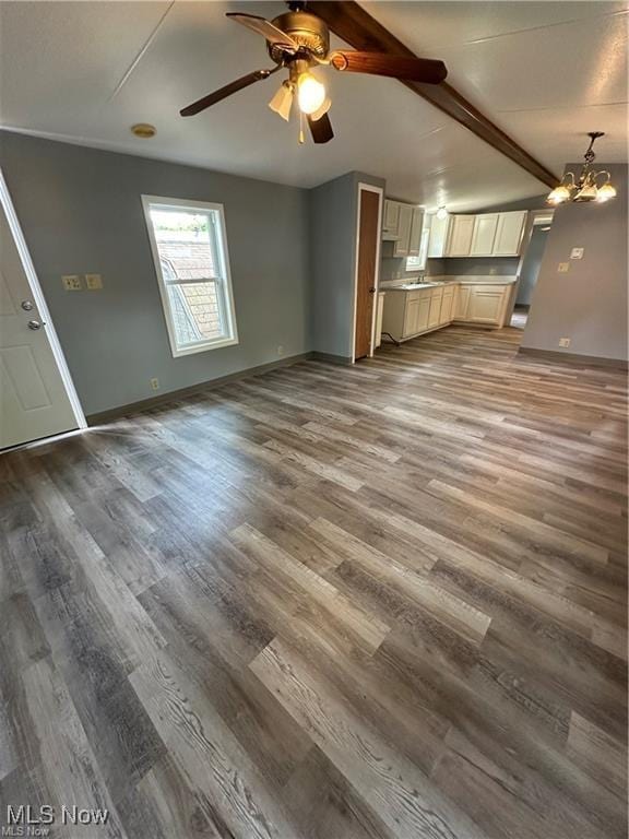 7443 Spillway Rd Unit 63, Lisbon, OH 44432 - unfurnished living room featuring wood finished floors, ceiling fan, a chandelier, and beam ceiling