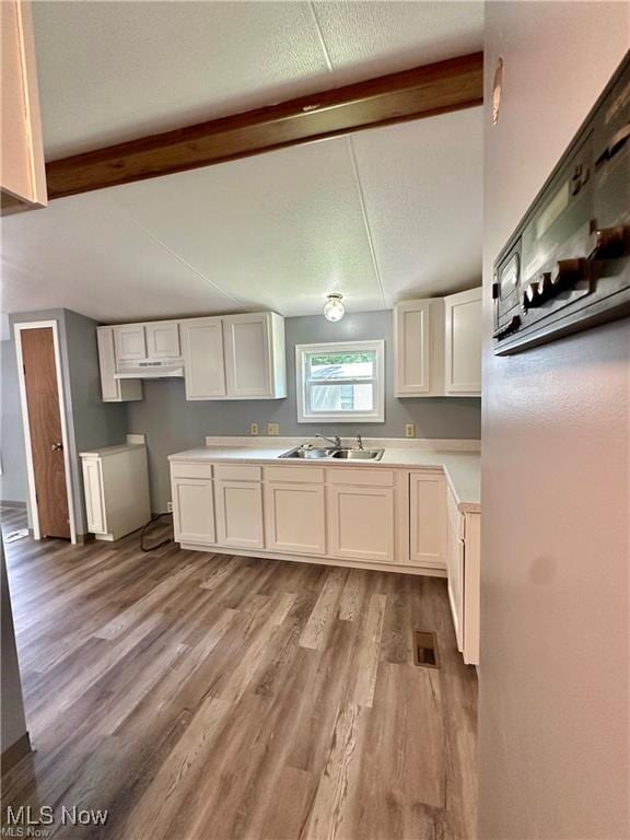 7443 Spillway Rd Unit 63, Lisbon, OH 44432 - kitchen featuring light wood finished floors, white cabinets, light countertops, and under cabinet range hood