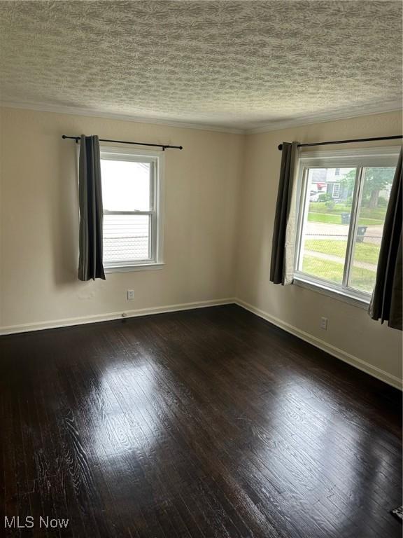 1042 Frederick Blvd, Akron, OH 44320 - empty room featuring healthy amount of natural light, crown molding, a textured ceiling, and dark wood-style flooring