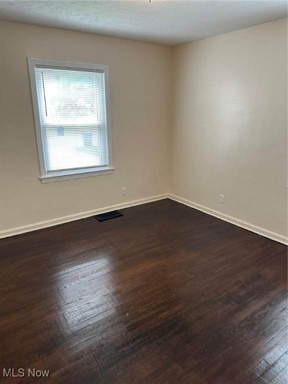 1042 Frederick Blvd, Akron, OH 44320 - spare room with dark wood-style floors and baseboards