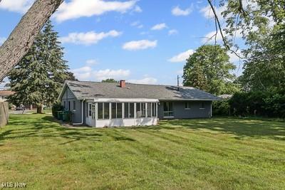 6265 Thunderbird Dr, Mentor, OH 44060 - back of property with a sunroom and a yard