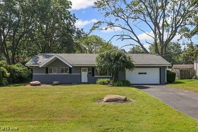 6265 Thunderbird Dr, Mentor, OH 44060 - ranch-style house with asphalt driveway, a front lawn, and an attached garage