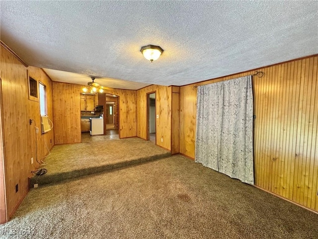 33 Knight Ln, Big Bend, WV 26136 - unfurnished living room with a textured ceiling, carpet, wood walls, and ceiling fan