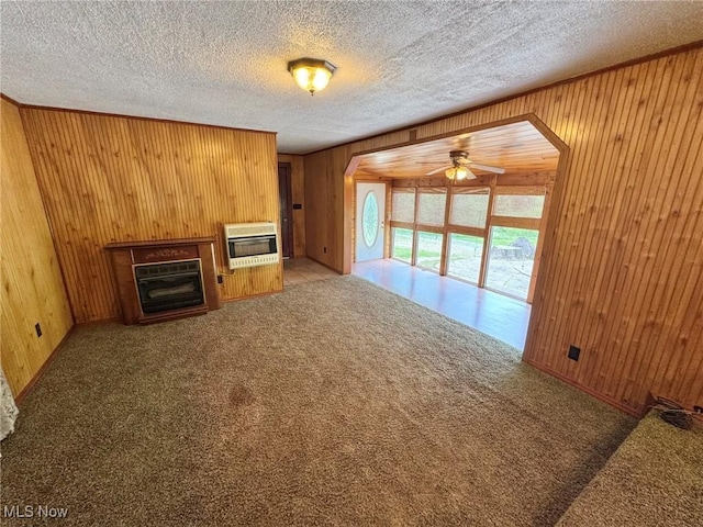 33 Knight Ln, Big Bend, WV 26136 - unfurnished living room with heating unit, ceiling fan, wood walls, arched walkways, and a fireplace