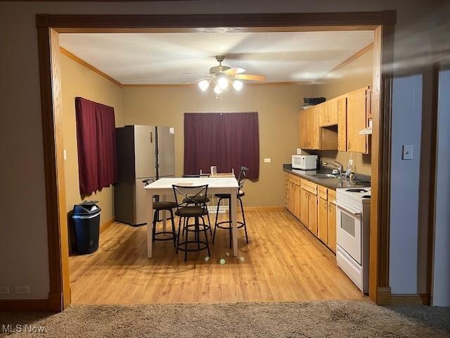 525 W 39th St, Shadyside, OH 43947 - kitchen with white appliances, ceiling fan, crown molding, dark countertops, and light wood-style floors