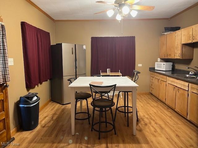 525 W 39th St, Shadyside, OH 43947 - kitchen with white appliances, crown molding, a ceiling fan, light wood finished floors, and dark countertops