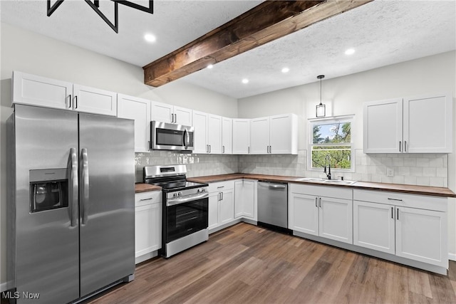 410 Elm St, Martins Ferry, OH 43935 - kitchen with stainless steel appliances, butcher block countertops, beam ceiling, tasteful backsplash, and dark wood-type flooring