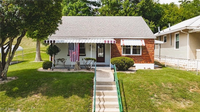 1713 26th St, Parkersburg, WV 26101 - view of front of property featuring roof with shingles, brick siding, and a front lawn