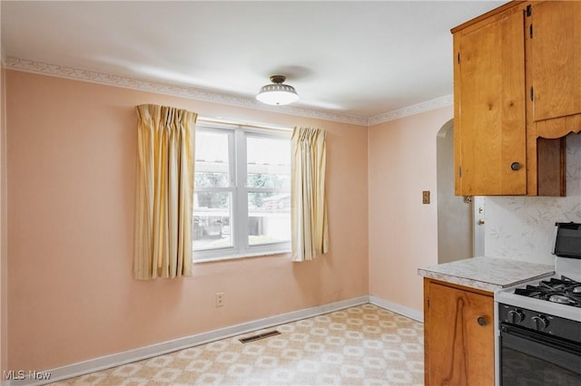 1713 26th St, Parkersburg, WV 26101 - kitchen featuring white gas range, arched walkways, light flooring, and brown cabinetry