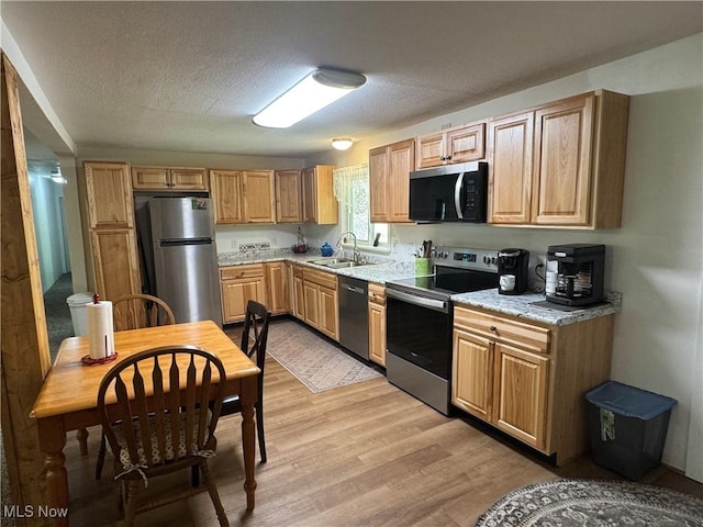 3028 Volcano Rd, Walker, WV 26180 - kitchen with appliances with stainless steel finishes, light wood-type flooring, a textured ceiling, and light stone countertops