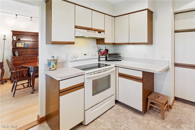 82 Pyle Rd, Oberlin, OH 44074 - kitchen with white range with electric stovetop, under cabinet range hood, light countertops, and white cabinetry
