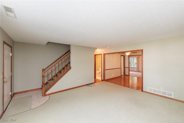 373 Chesapeake Cv, Painesville, OH 44077 - unfurnished living room featuring carpet flooring, stairs, and ceiling fan