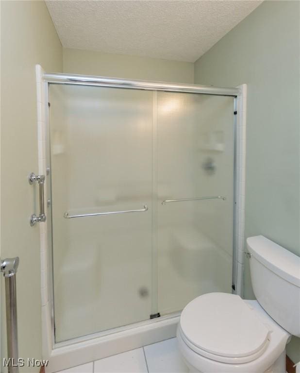 373 Chesapeake Cv, Painesville, OH 44077 - bathroom with a stall shower, a textured ceiling, and tile patterned floors