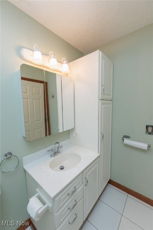 373 Chesapeake Cv, Painesville, OH 44077 - bathroom with vanity, tile patterned flooring, and a textured ceiling