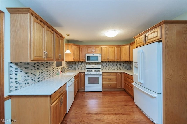 373 Chesapeake Cv, Painesville, OH 44077 - kitchen with white appliances, light wood-style flooring, decorative backsplash, and light countertops