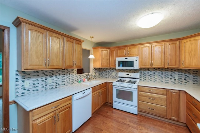 373 Chesapeake Cv, Painesville, OH 44077 - kitchen featuring white appliances, light countertops, tasteful backsplash, light wood finished floors, and a textured ceiling