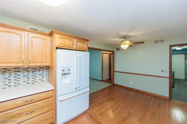 373 Chesapeake Cv, Painesville, OH 44077 - kitchen featuring white fridge with ice dispenser, light wood finished floors, ceiling fan, backsplash, and light countertops