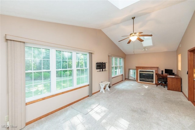 373 Chesapeake Cv, Painesville, OH 44077 - unfurnished living room with a skylight, a glass covered fireplace, lofted ceiling, carpet, and ceiling fan