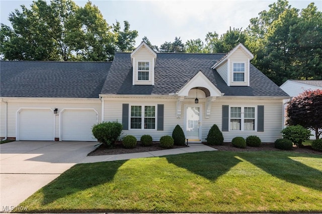 373 Chesapeake Cv, Painesville, OH 44077 - cape cod-style house featuring an attached garage, concrete driveway, a front yard, and a shingled roof