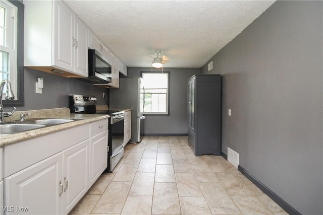 3316 S Canfield Niles Rd, Canfield, OH 44406 - kitchen featuring stainless steel appliances, white cabinets, a textured ceiling, ceiling fan, and light countertops