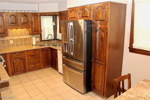 195 W 10th St, Salem, OH 44460 - kitchen with stainless steel fridge, backsplash, dishwasher, brown cabinets, and light tile patterned flooring