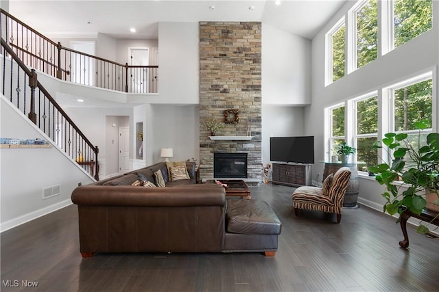 7319 Montella Ave NW, Canal Fulton, OH 44614 - living area featuring high vaulted ceiling, stairs, healthy amount of natural light, a stone fireplace, and wood finished floors