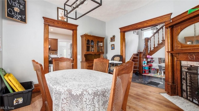 576 N Main St, Utica, OH 43080 - dining space with light wood-style flooring, a fireplace with flush hearth, and stairs