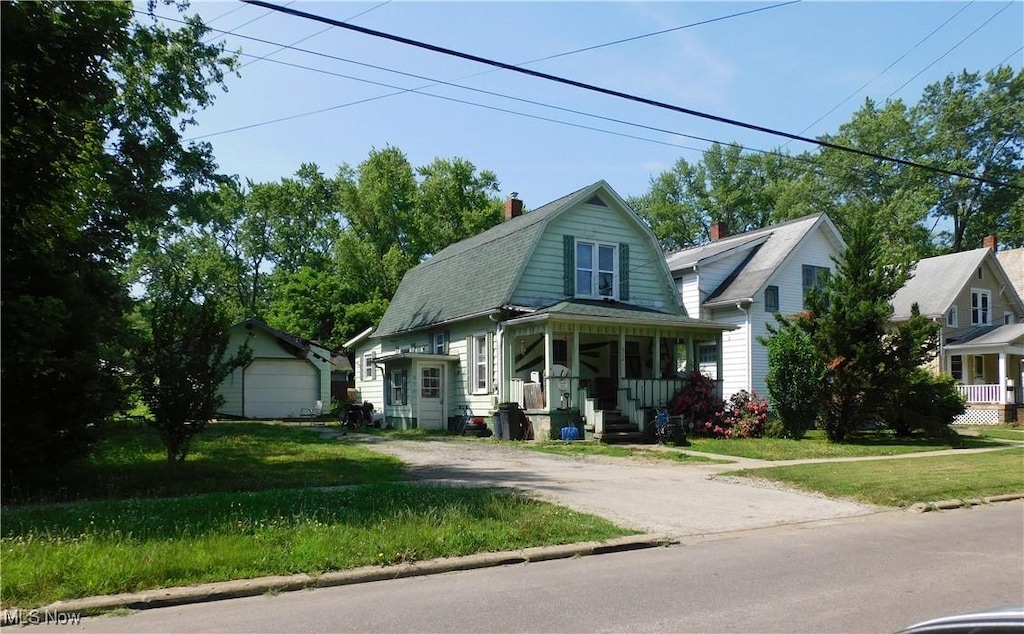 814 W 58th St, Ashtabula, OH 44004 - colonial inspired home featuring a gambrel roof, a chimney, a front lawn, and driveway
