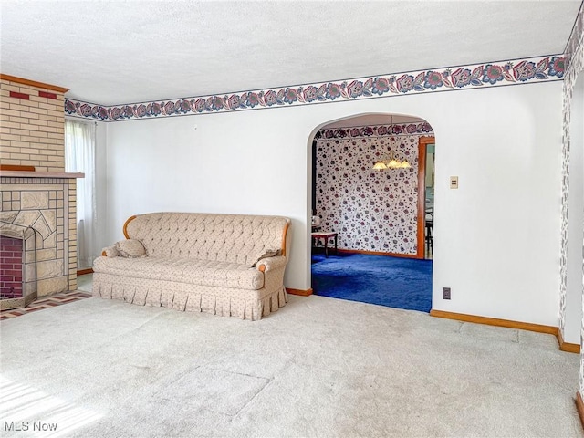 1120 N 5th St, Toronto, OH 43964 - carpeted living area with arched walkways, a textured ceiling, and a fireplace