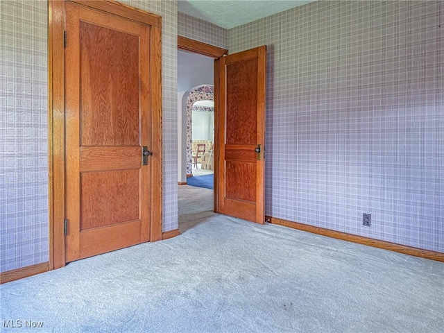 1120 N 5th St, Toronto, OH 43964 - unfurnished bedroom with wallpapered walls, carpet, and arched walkways