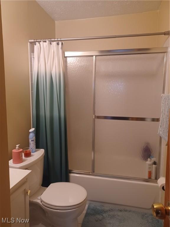 130 Fairground Blvd, Canfield, OH 44406 - bathroom featuring combined bath / shower with glass door, vanity, and a textured ceiling