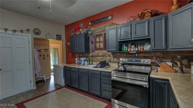 217 Mclaughlin Ave, Byesville, OH 43723 - kitchen featuring stainless steel electric stove, backsplash, light countertops, wood finished floors, and open shelves