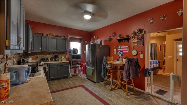 217 Mclaughlin Ave, Byesville, OH 43723 - kitchen with freestanding refrigerator, ceiling fan, light countertops, light wood-style flooring, and gray cabinets
