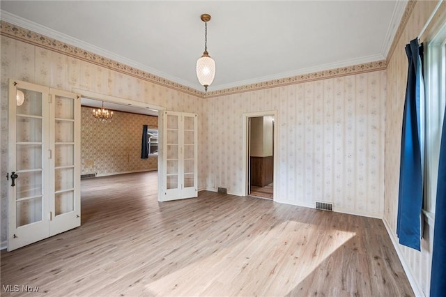 158 Elm St, Leetonia, OH 44431 - empty room with french doors, wood finished floors, a chandelier, ornamental molding, and wallpapered walls