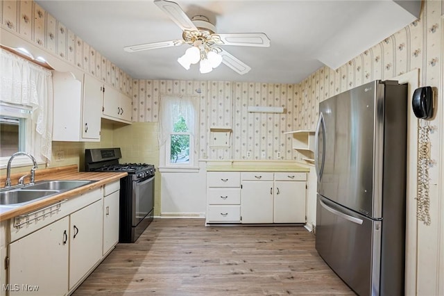 158 Elm St, Leetonia, OH 44431 - kitchen featuring stainless steel appliances, wallpapered walls, ceiling fan, light countertops, and light wood-type flooring