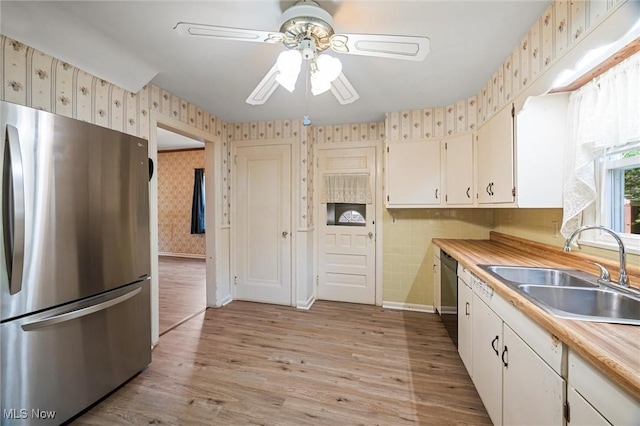 158 Elm St, Leetonia, OH 44431 - kitchen featuring stainless steel appliances, wallpapered walls, ceiling fan, light countertops, and light wood-type flooring