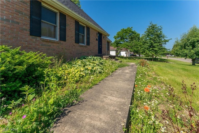 233 Robbies Run, Cortland, OH 44410 - view of side of property featuring brick siding and a yard