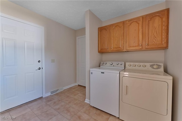 233 Robbies Run, Cortland, OH 44410 - washroom with washer and clothes dryer, cabinet space, a textured ceiling, and light tile patterned floors