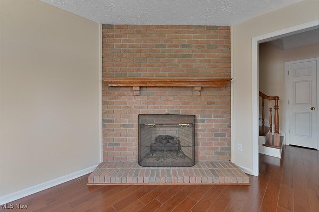 233 Robbies Run, Cortland, OH 44410 - detailed view of wood finished floors, a fireplace, and a textured ceiling