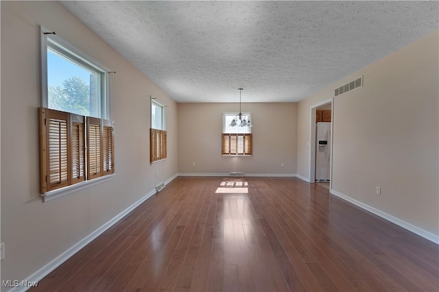 233 Robbies Run, Cortland, OH 44410 - spare room featuring a textured ceiling, a chandelier, and dark wood-style flooring