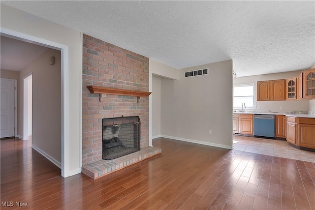 233 Robbies Run, Cortland, OH 44410 - unfurnished living room featuring a textured ceiling, light wood-type flooring, and a fireplace